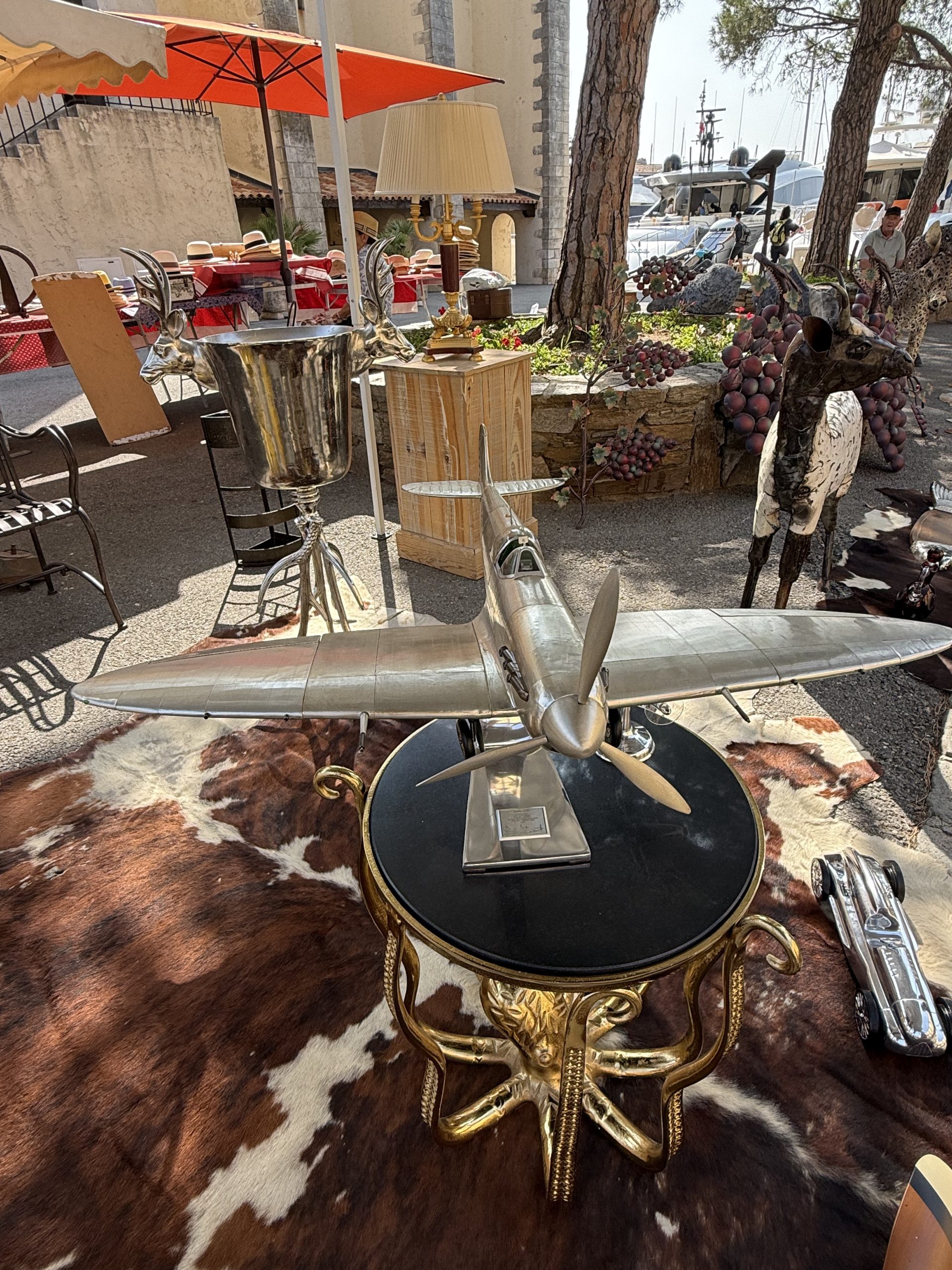 Maquette d'avion en métal posée sur un guéridon à piètement doré et plateau noir