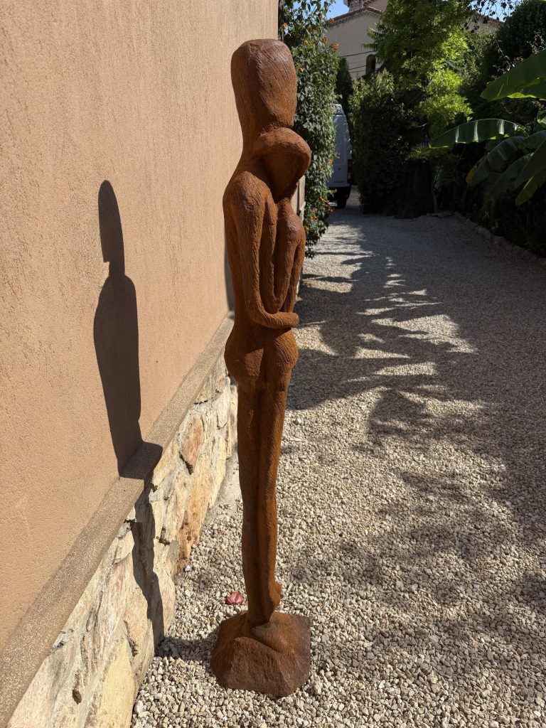 Grande sculpture en bois d'une silhouette humaine élancée, patine rouille